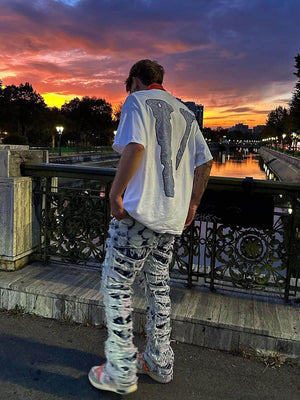 Jeans deshilachados con efecto bleach – foto urbana, de espalda | XoKool