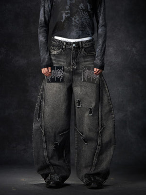 Black Ripped Barrel Jeans with Gothic Letter Patches – on model, front (patch close) | XoKool