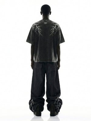 Schwarze Stacked Jeans mit Blitz-Graphics – am Model, Rückansicht | XoKool