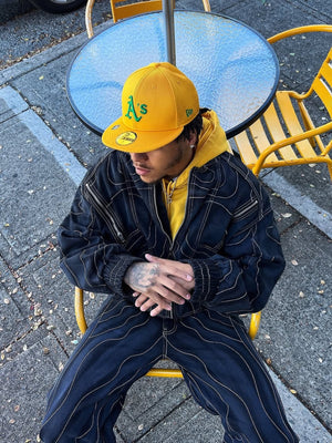 Cropped Black Denim Bomber Jacket with Curved Stitching – on model, seated | XoKool