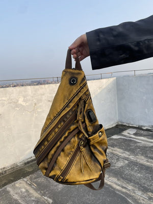 Distressed Washed Sling Chest Bag – Yellow, held in hand outdoors | XoKool
