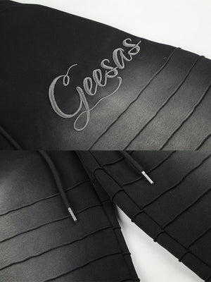 Pleated sweatpants – Black embroidery and pleats close-up | XoKool