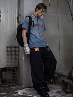 Embroidered sweatpants – Black, on model leaning | XoKool
