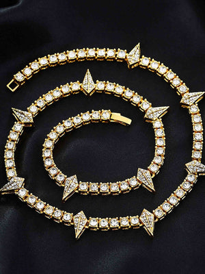 Collar de cadena tennis con strass y púas – dorado, enrollado sobre fondo negro | XoKool