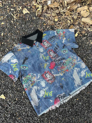Graffiti denim shirt – flat lay on gravel | XoKool