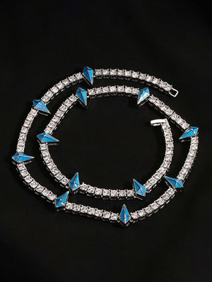 Collar de cadena tennis con strass y púas – púa azul plateada, enrollado sobre fondo negro | XoKool