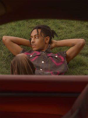 Spray Paint Heart Denim Vest – Washed Black, on model lying on grass | XoKool