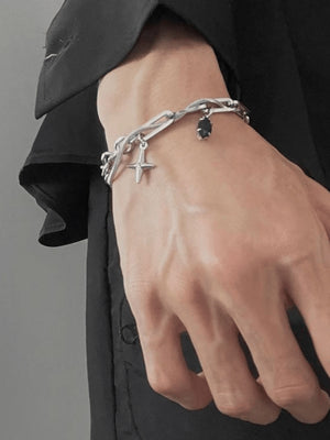 Pulsera de cadenas en capas color plata con charm de estrella – en la muñeca de la modelo | XoKool