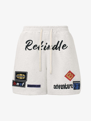 Sweat-Shorts mit gestickten Patches – Hafer, Vorderseite flach | XoKool