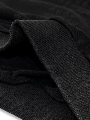 Hoodie gráfico con cruz en negro lavado – detalle de la tela y el dobladillo | XoKool