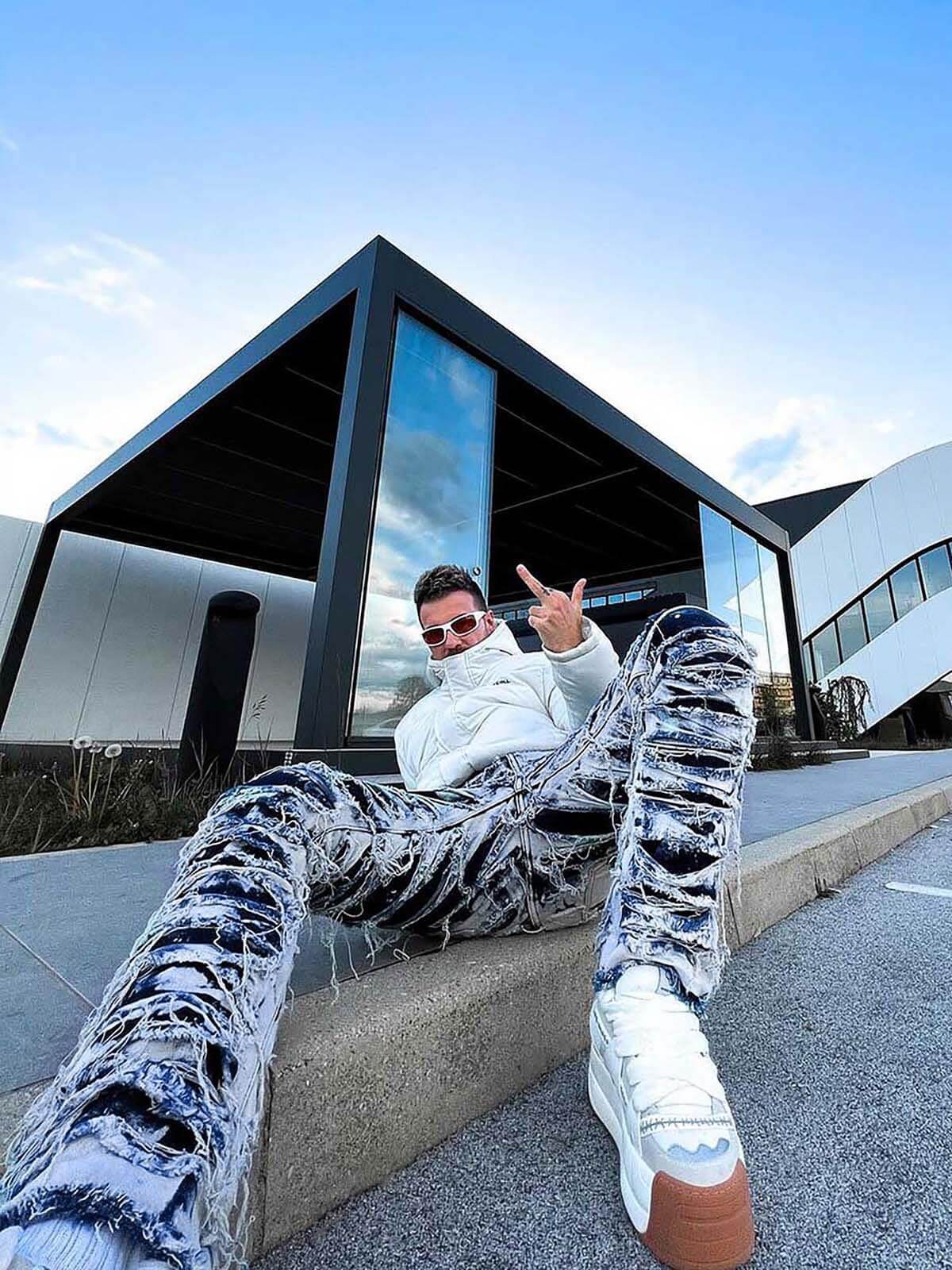 Jeans deshilachados con efecto bleach – foto urbana, sentada | XoKool