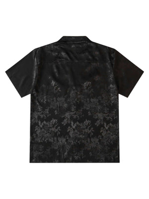 Step into sleek sophistication with the Leaves Pattern Black Vintage Shirt — a versatile piece that blends vintage charm with modern elegance. Made from smooth satin fabric, this short-sleeved shirt features a notched lapel collar, button-up front, and a