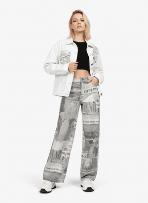 Baggy Jeans mit Zeitungsprint – am Model (Frau), Vorderansicht komplett mit weißer Jeansjacke | XoKool