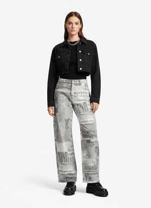 Baggy Jeans mit Zeitungsprint – am Model (Frau), Vorderansicht komplett mit schwarzer Jeansjacke | XoKool