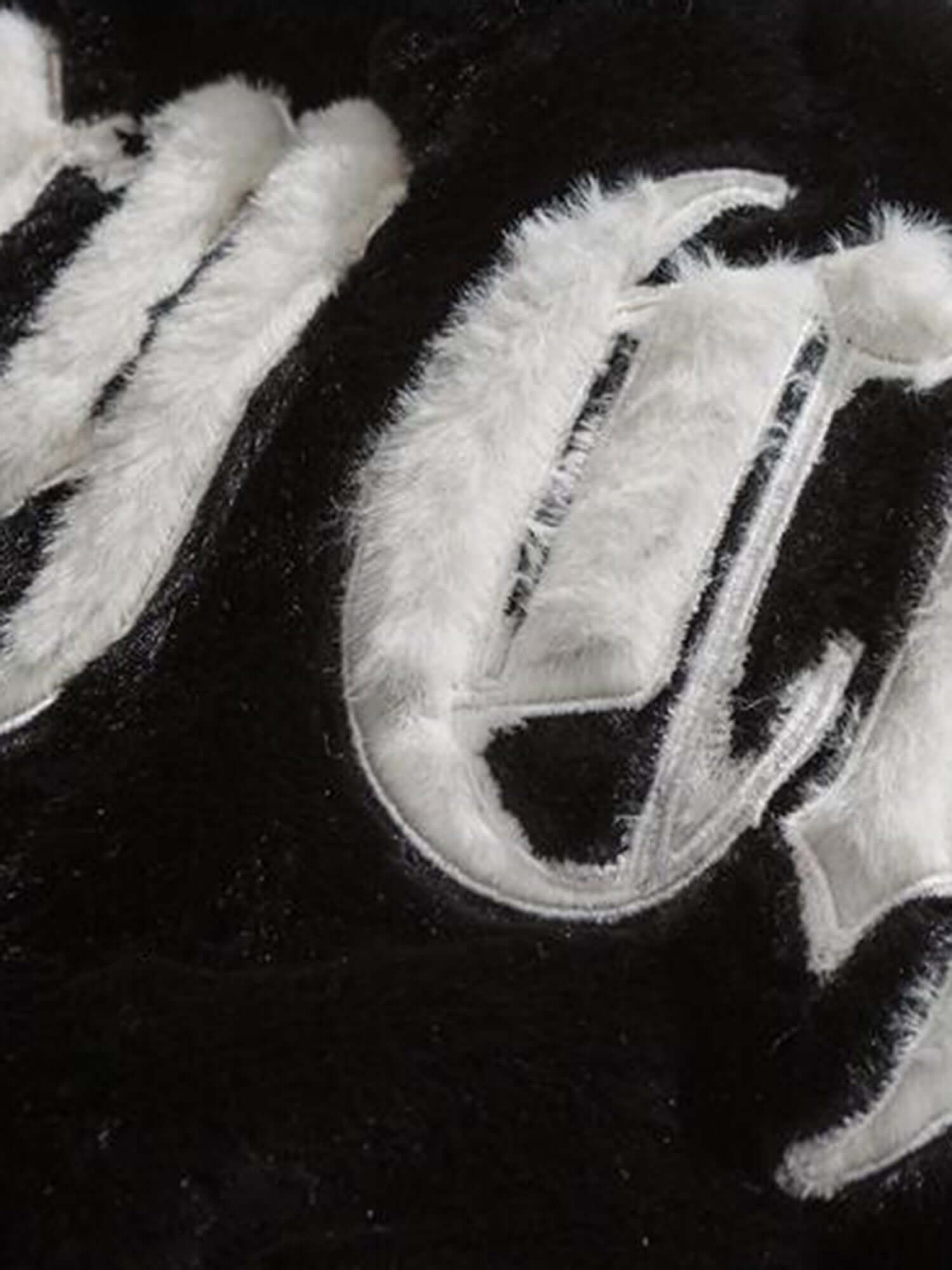 Make a bold impression with the Street Letter Embroidered Fleece Jacket. Crafted from ultra-soft faux fur, this oversized winter essential combines warmth, comfort, and eye-catching streetwear design. The jacket features bold embroidered text across the b