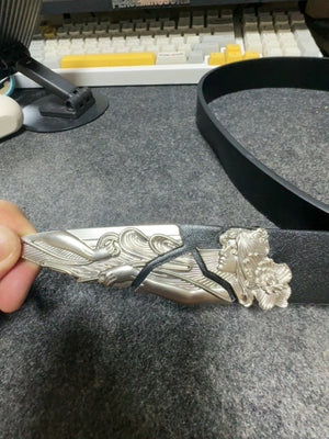 Gürtel mit gravierter Schnalle – Detail der Spitze, in der Hand | XoKool