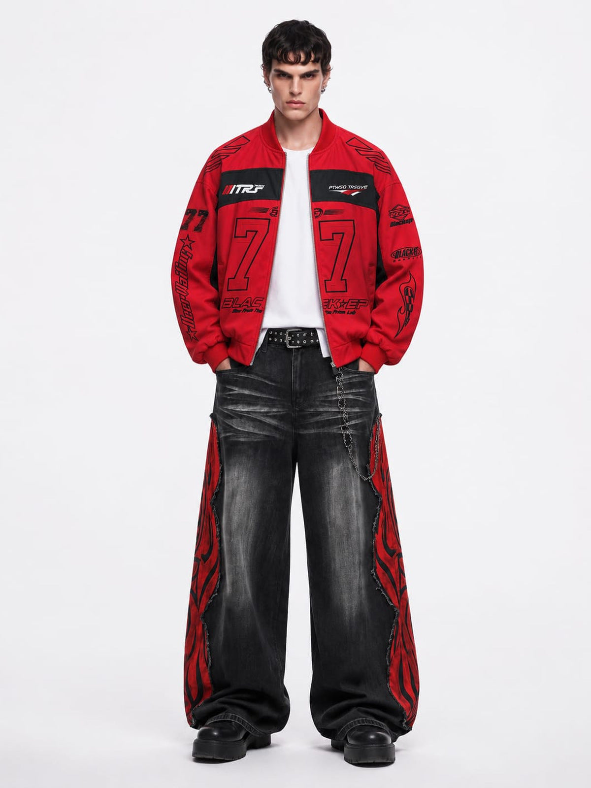 Schwarze Wide Leg Jeans mit roten Flammen-Einsätzen – am Model von vorn (kombiniert mit roter Jacke) | XoKool