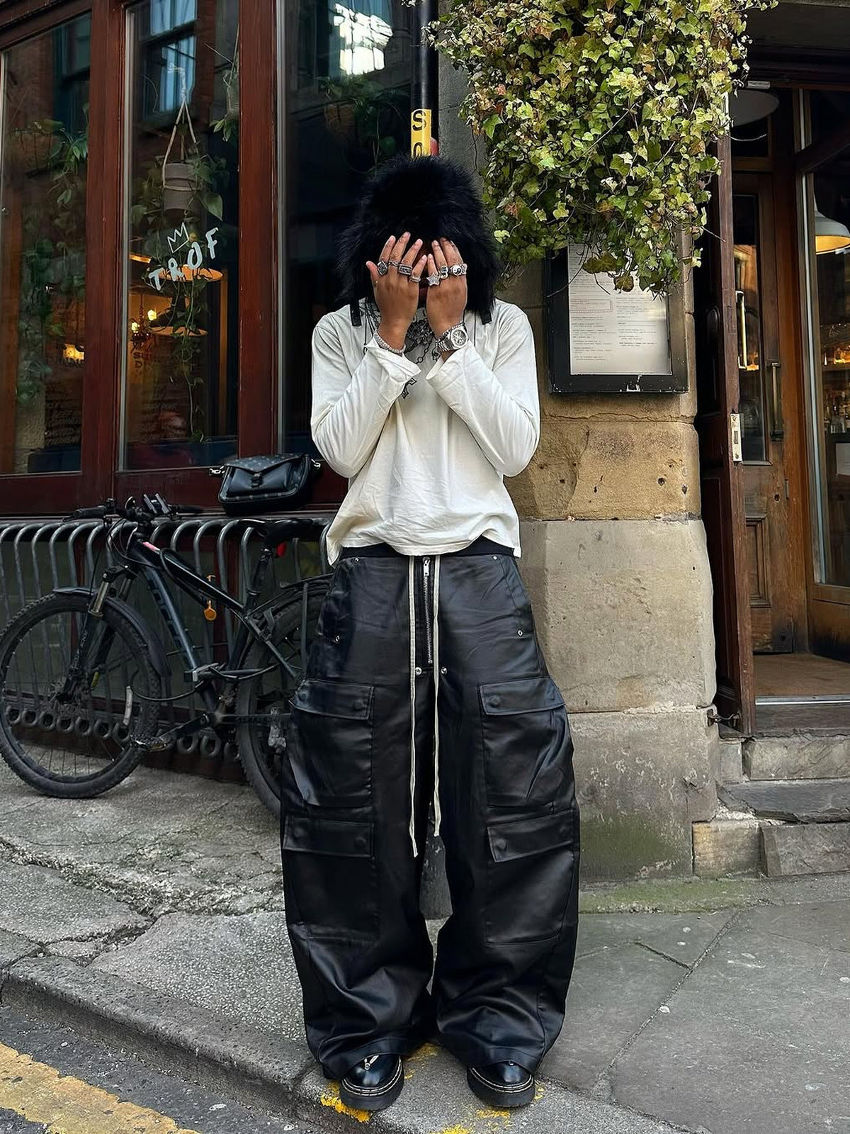 Coated Black Wide Leg Cargo Pants – Street photo, model covering face | XoKool