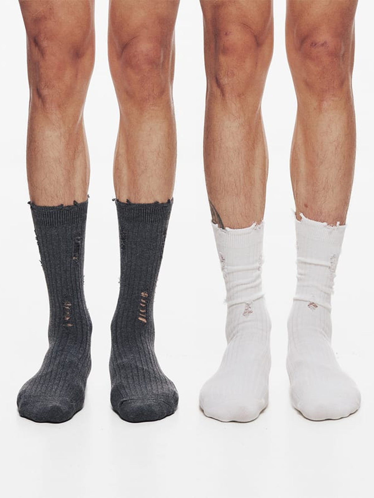 Calcetines slouch de canalé desgastados (distressed) – Gris oscuro y blanco, en las piernas de la modelo | XoKool