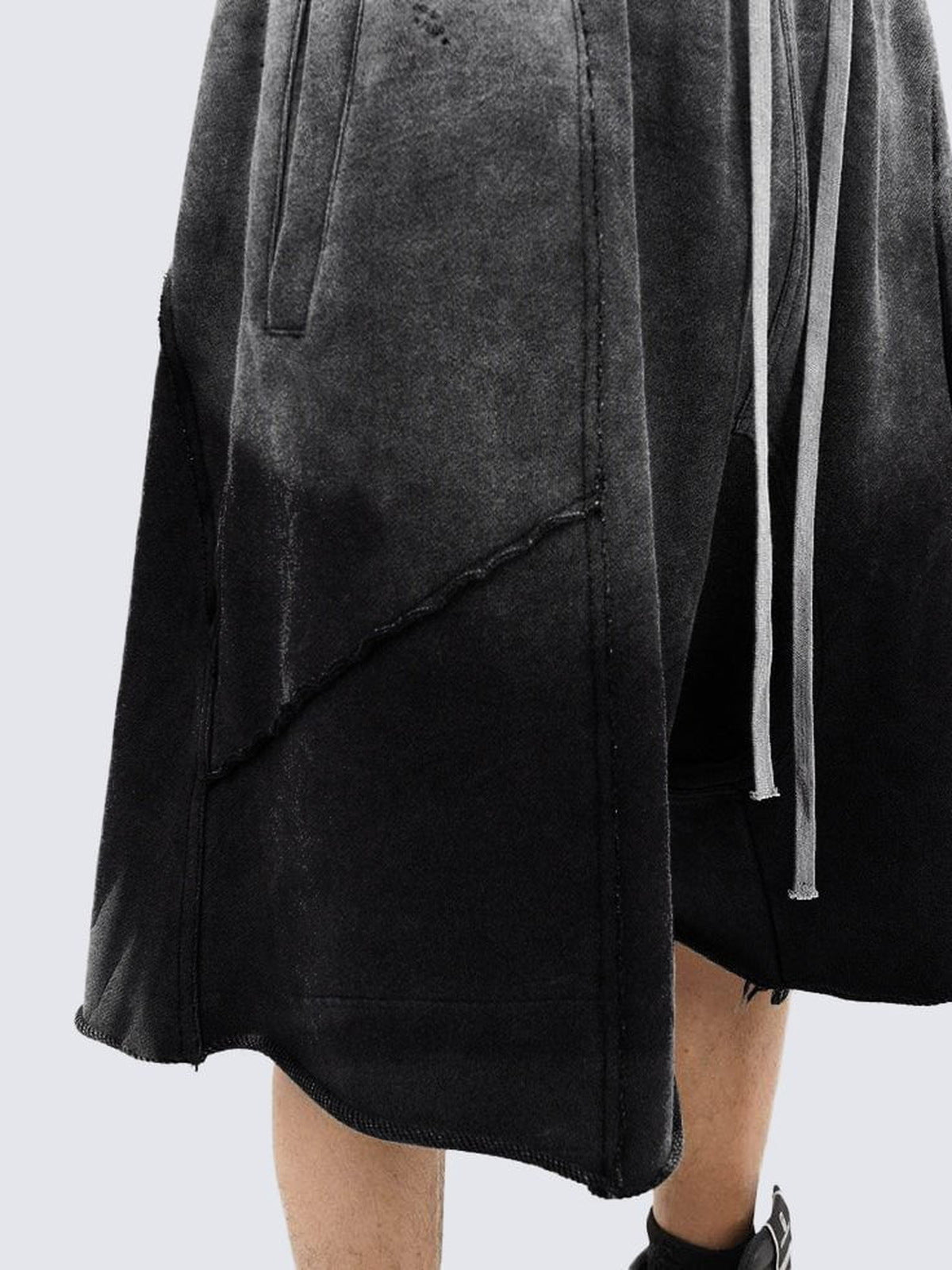 Shorts deportivos de tiro caído en negro desvaído – detalle de la abertura lateral y el cordón | XoKool