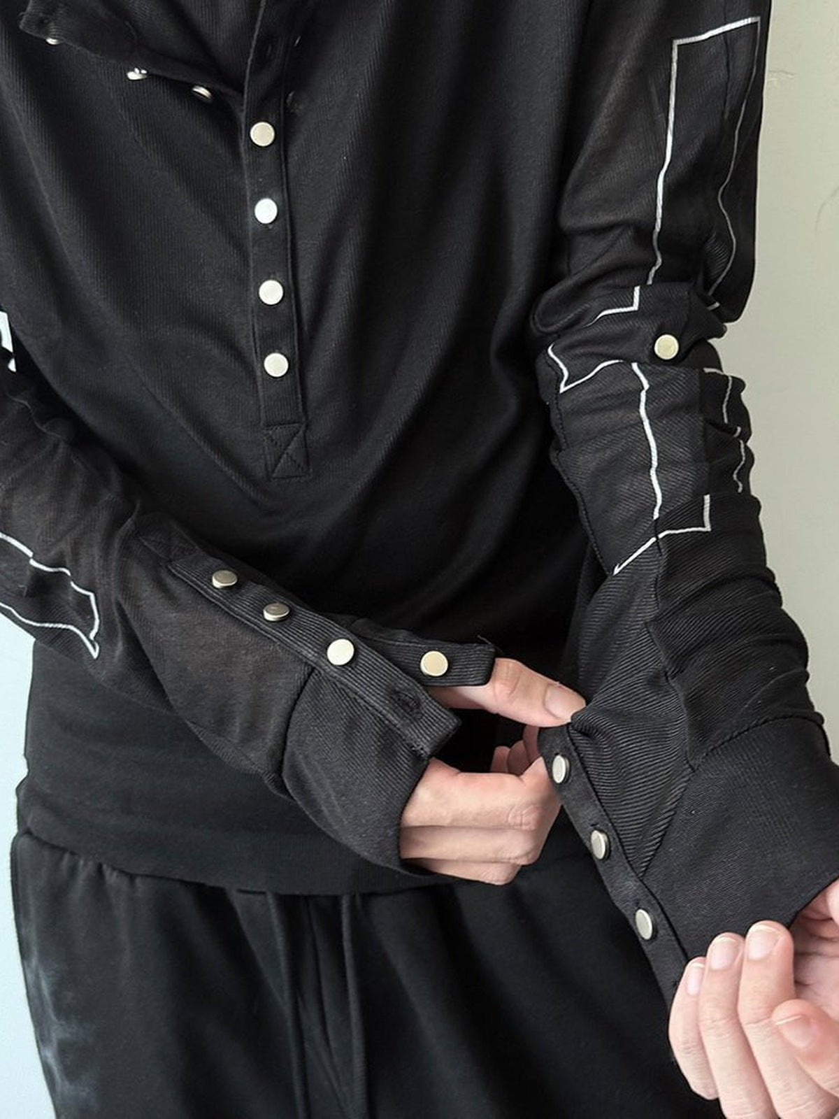 Henley con capucha – Negro, primer plano de los puños con broches y la botonadura | XoKool