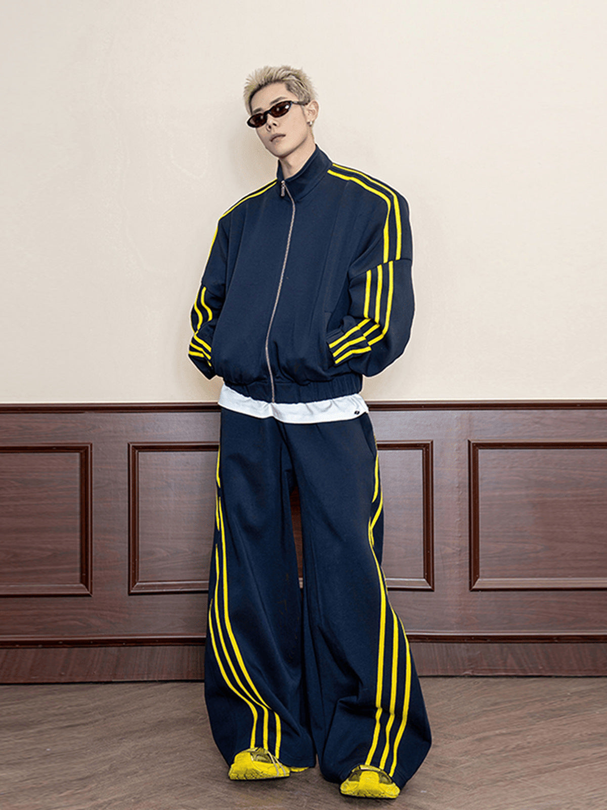 Marineblaue Trainingsjacke mit gelben Ärmelstreifen – am Model, komplettes Outfit mit passender Hose | XoKool