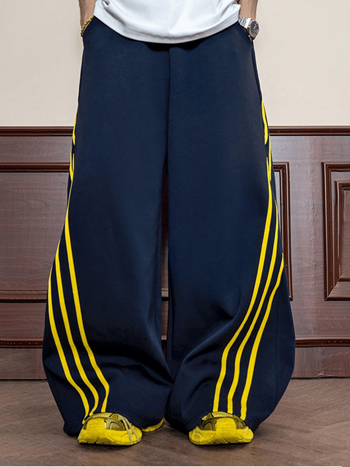 Pantalones deportivos de pierna ancha azul marino con rayas amarillas – en modelo, frente, piernas | XoKool