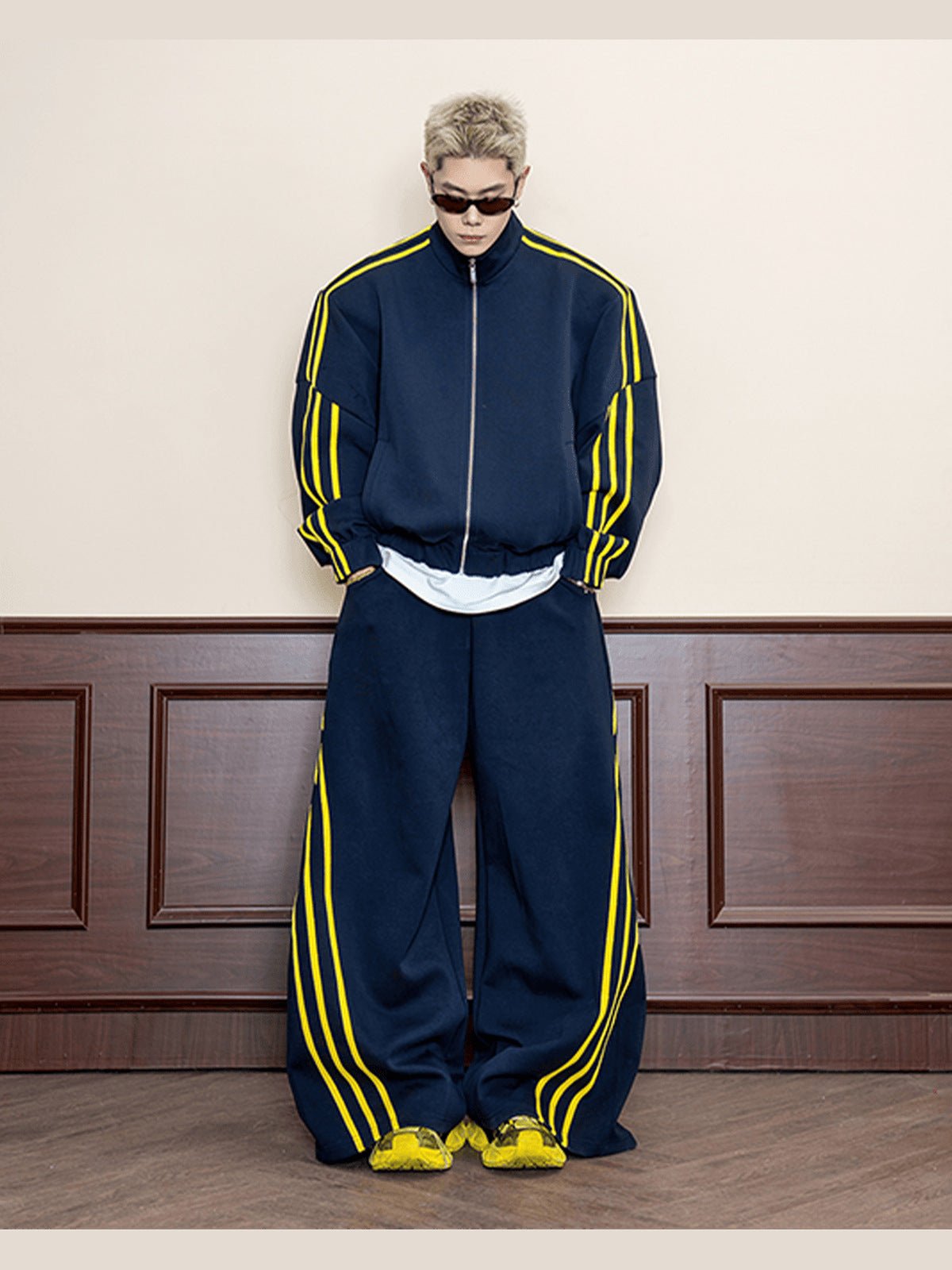 Marineblaue Trainingshose mit weitem Bein und gelben Streifen – am Model von vorne mit passender Trainingsjacke | XoKool