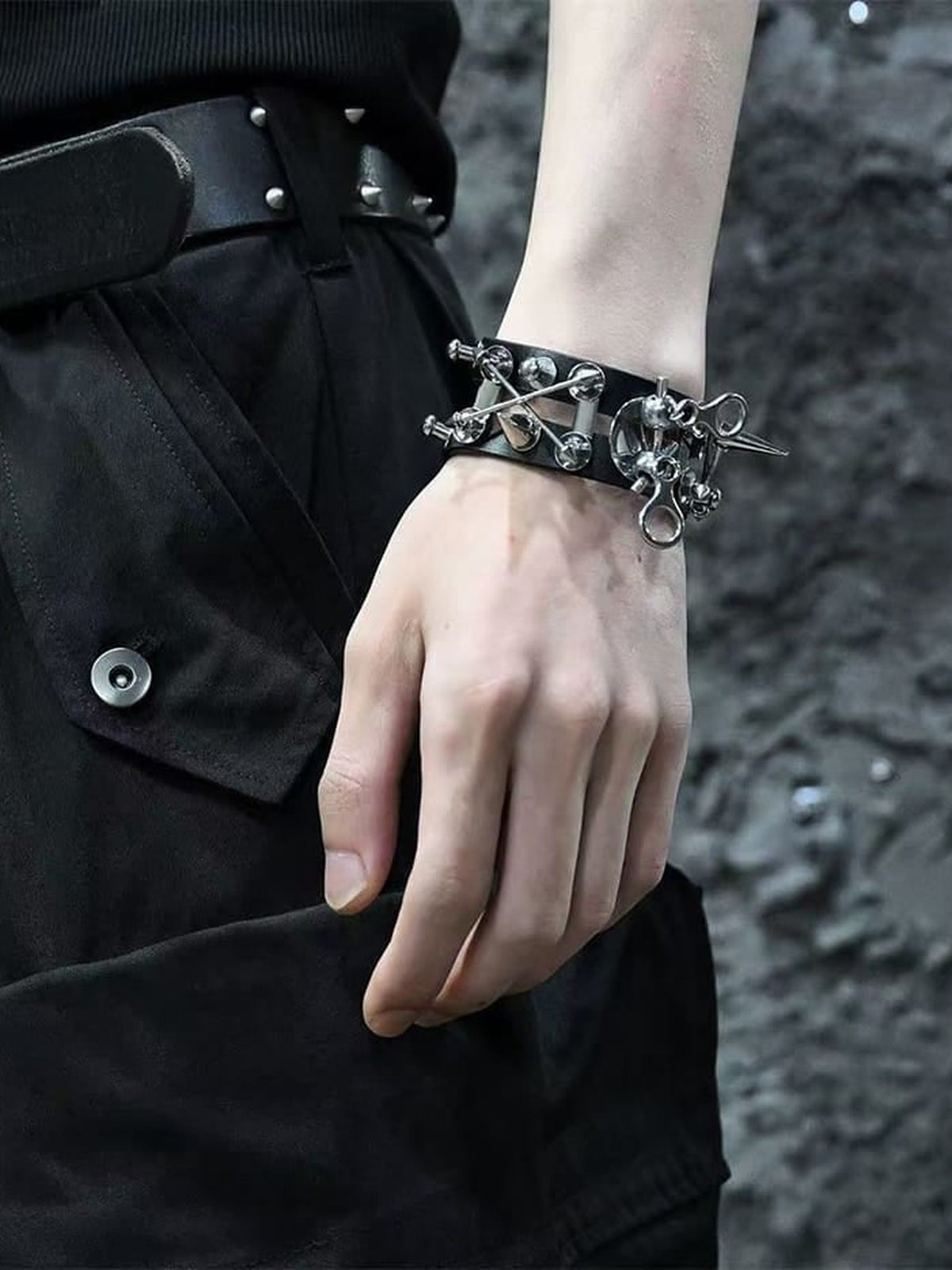 Muñequera de cuero sintético con calavera y pinchos – en la muñeca, en modelo con outfit negro | XoKool