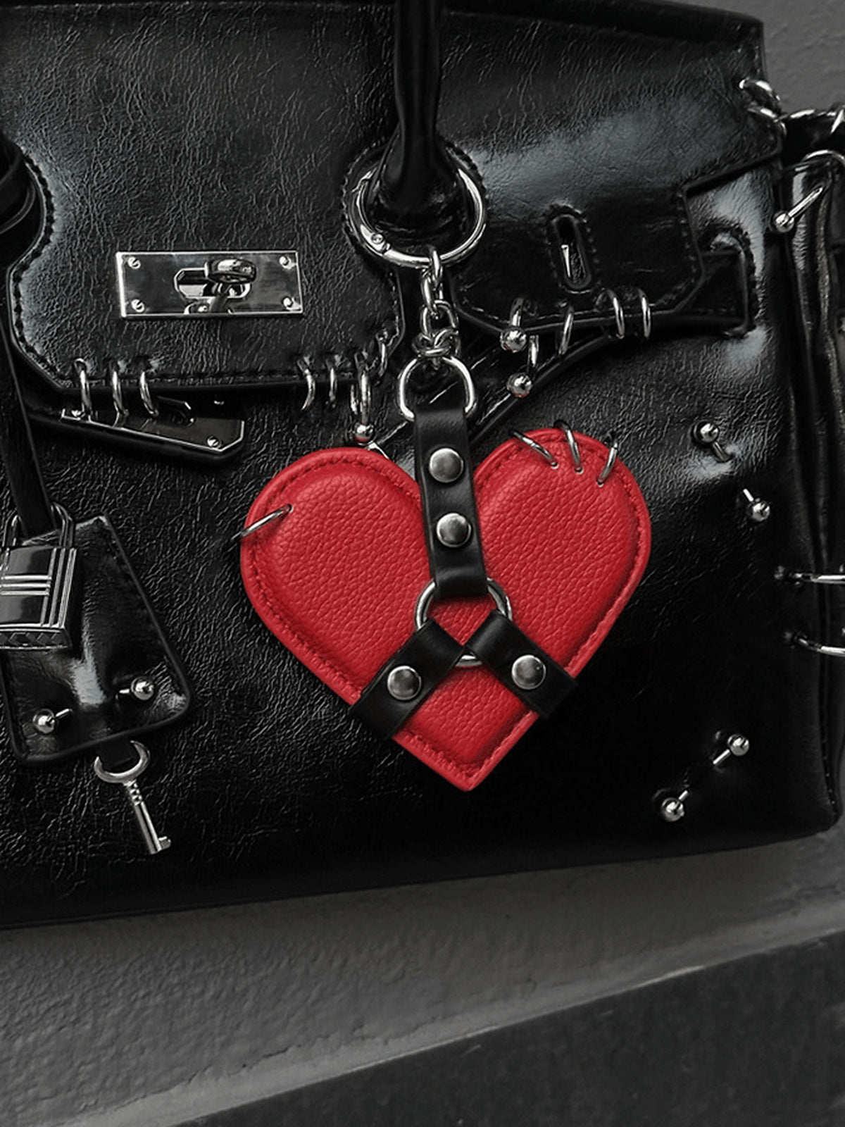 Taschenanhänger in Herzform mit Nieten und Harness-Band – roter Anhänger an schwarzer Tasche | XoKool