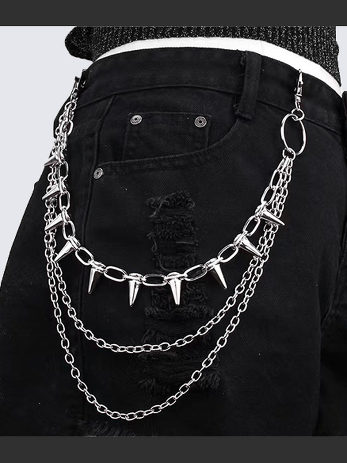 Cadena de pantalón plateada con púas en triple capa – en modelo, sujeta a jeans negros | XoKool