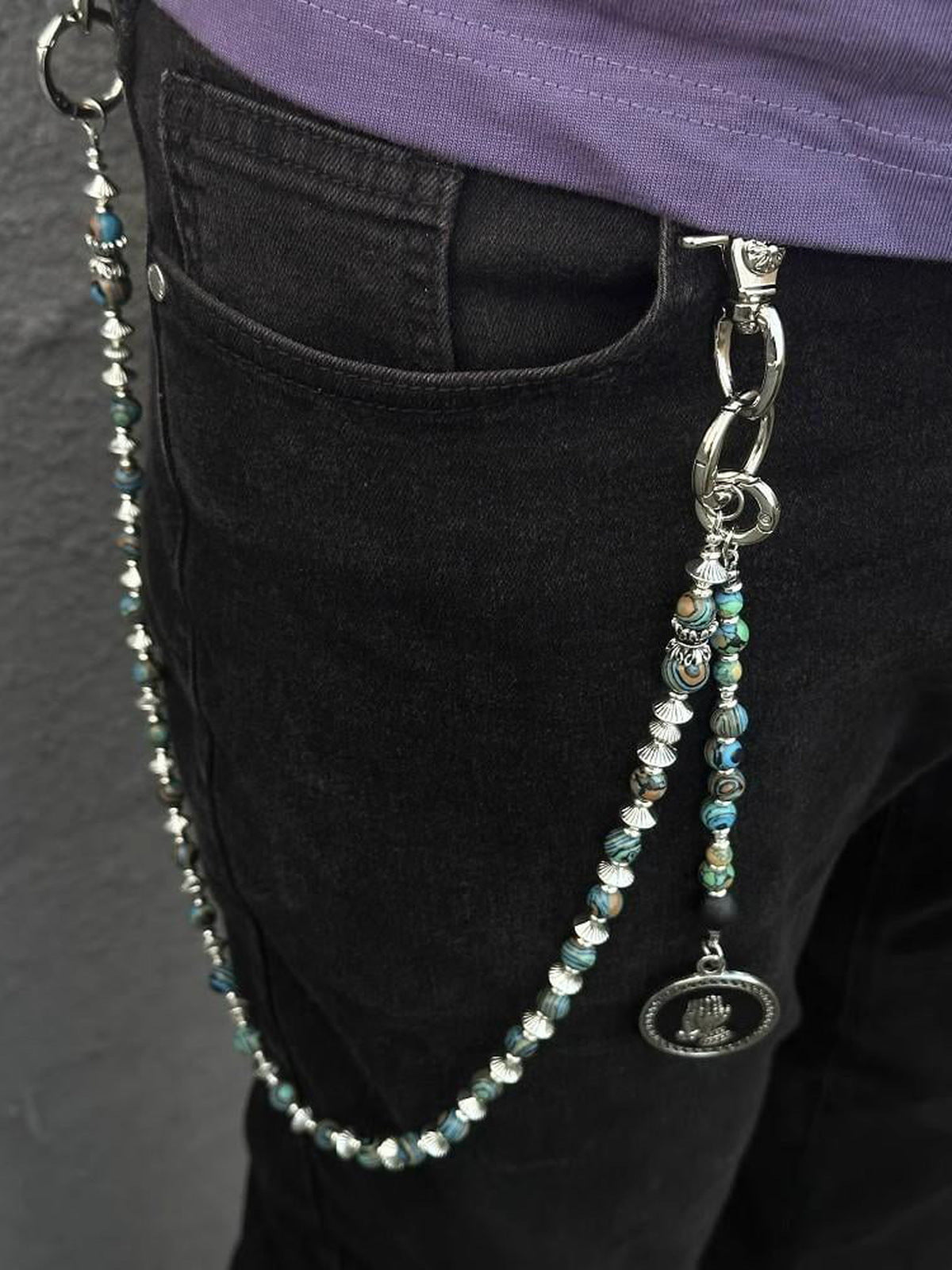 Jeanskette mit Türkis-Optik-Perlen und Medaillon – an schwarzer Jeans | XoKool