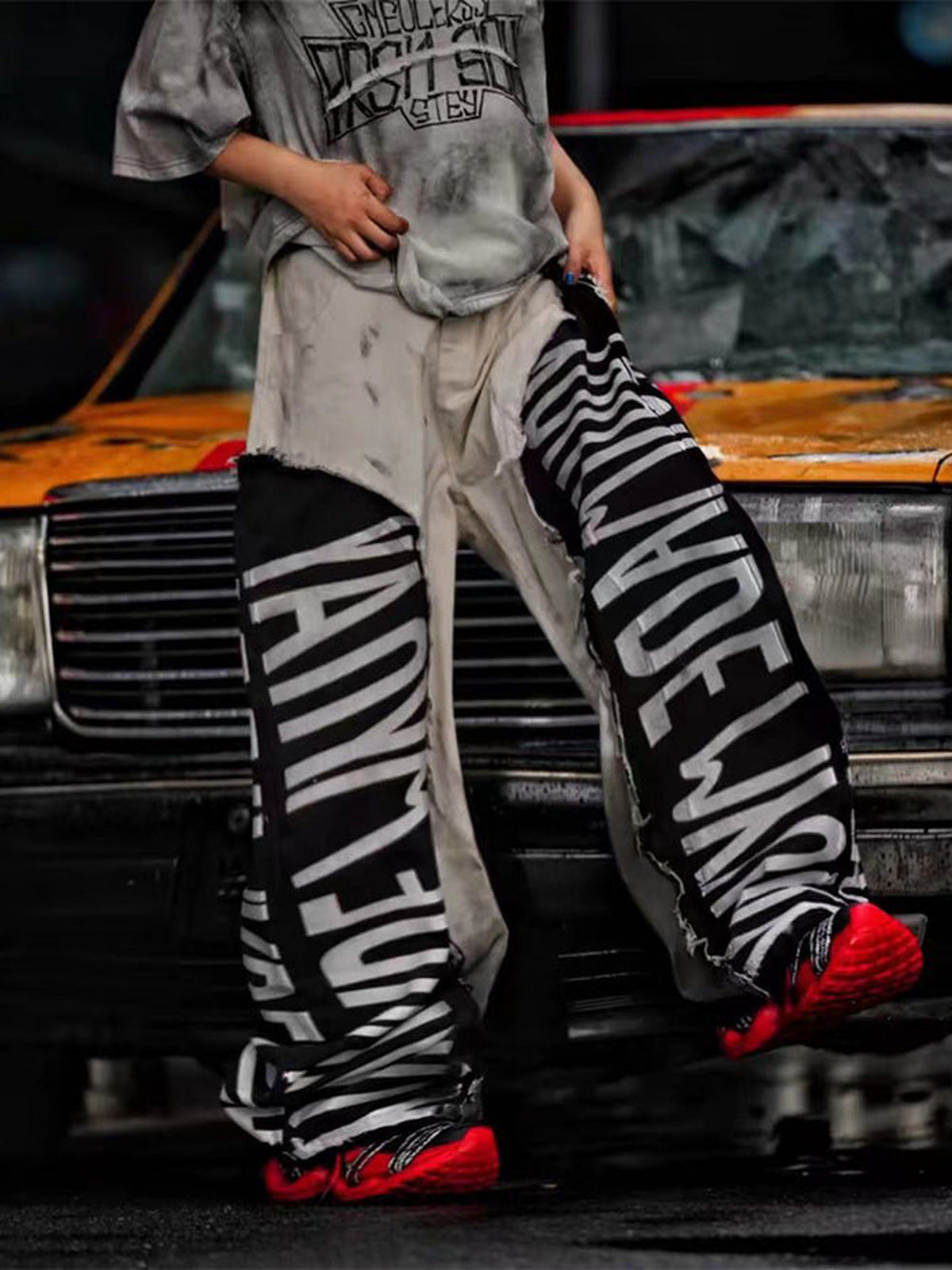 Weiße Barrel Jeans mit schwarzen Schriftzug-Einsätzen – am Model, Seitenschritt, Street-Foto | XoKool